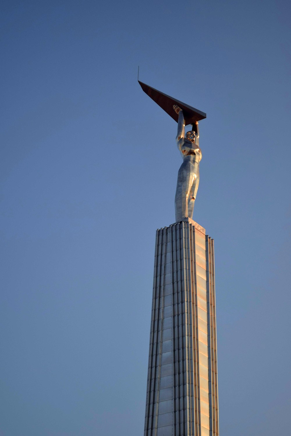 a tall building with a statue on top