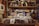 A vintage record store display features a wide array of vinyl records sorted into sections, with prominent labels. Above the records, retro figurines and posters of jazz musicians and album covers are displayed, creating a nostalgic atmosphere.