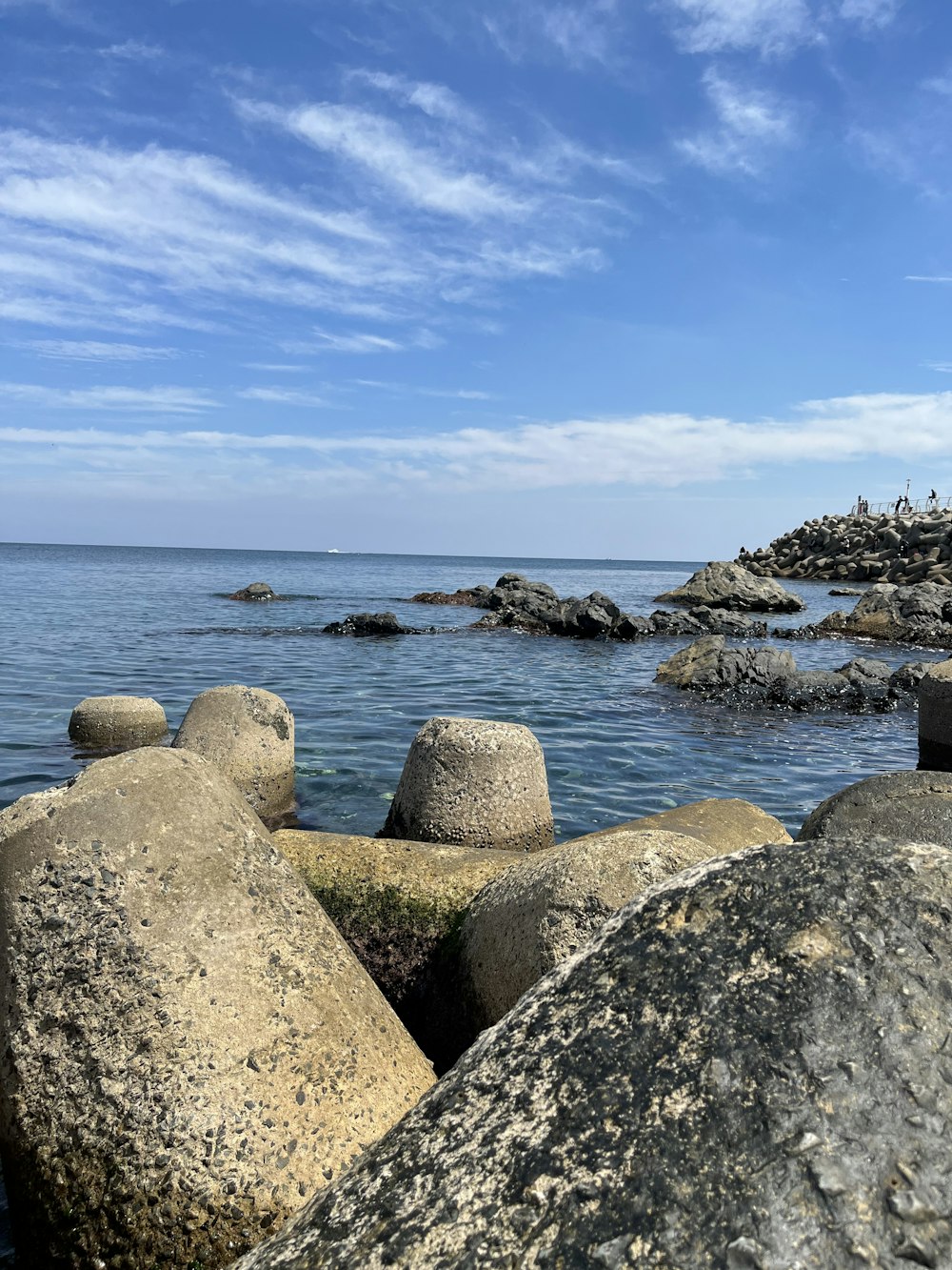 uma praia rochosa com um corpo de água no fundo