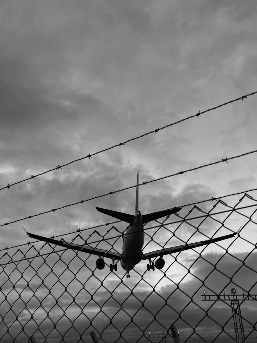 Un aereo che sorvola una recinzione