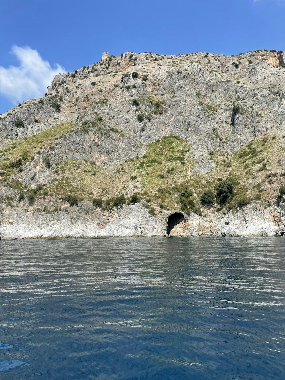 a cliff with a cave in the water