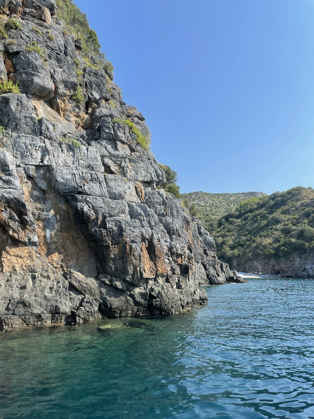 a cliff side with a body of water below