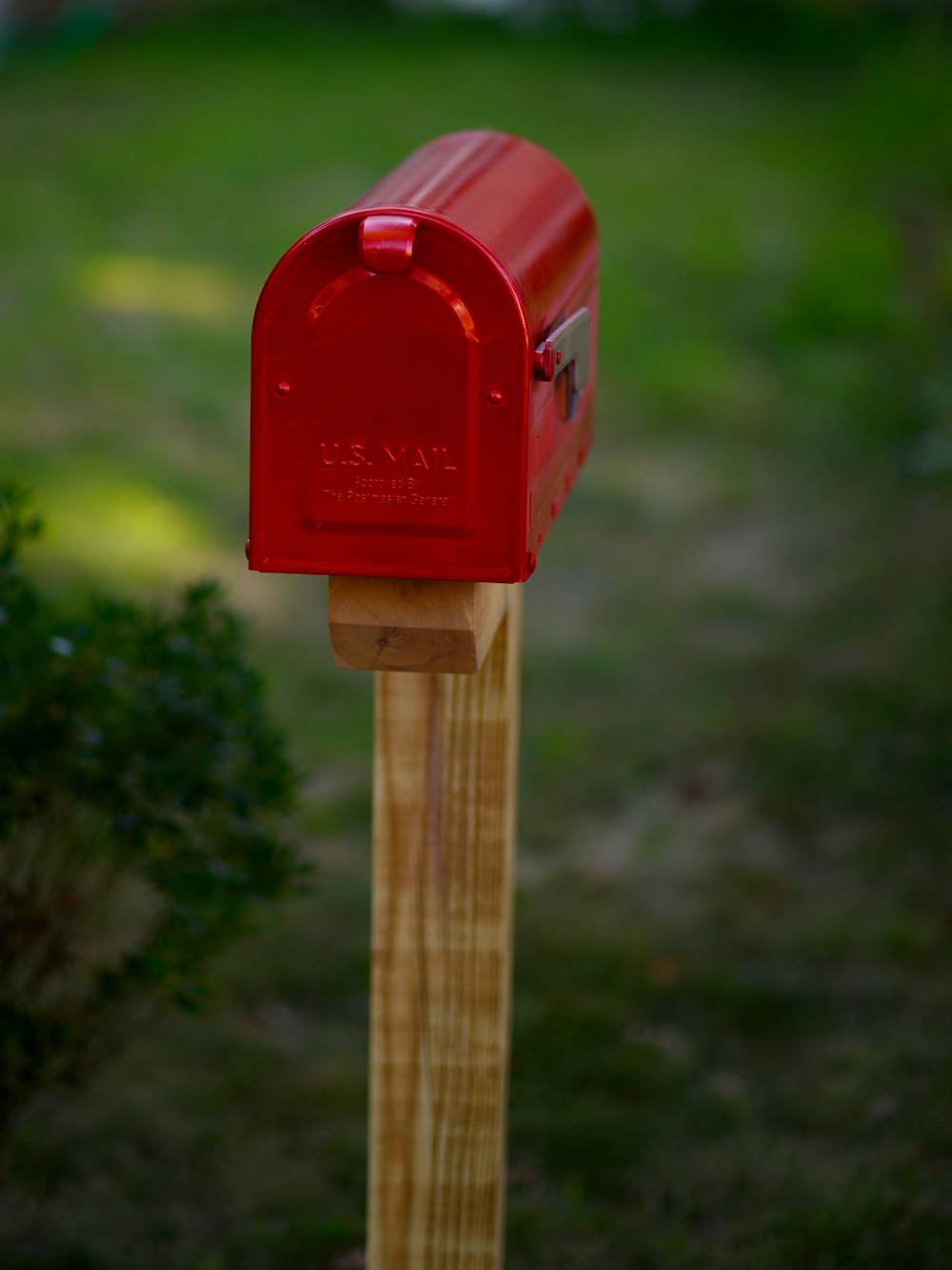 Una cassetta postale rossa su un palo di legno