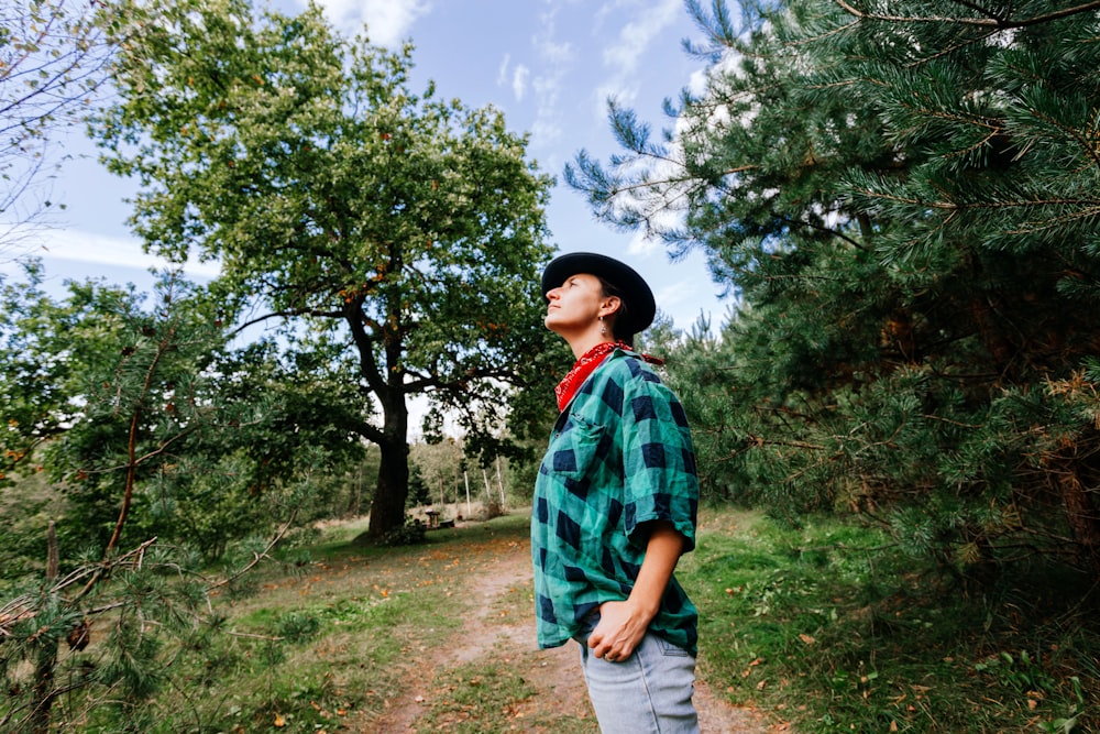 a boy standing on a path surrounded by trees