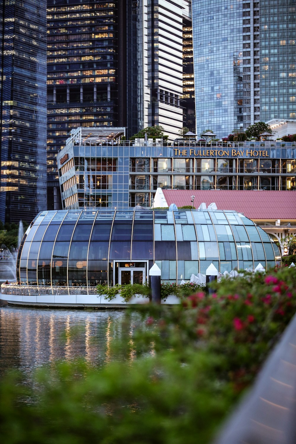 a building with glass walls and a body of water in front of it