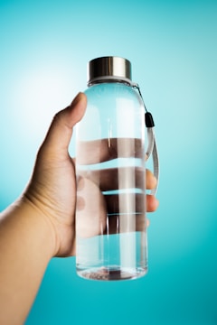 a hand holding a bottle of water