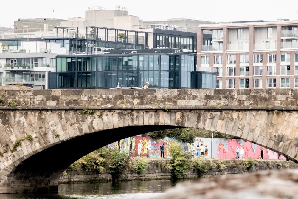 a bridge over a river with buildings in the background