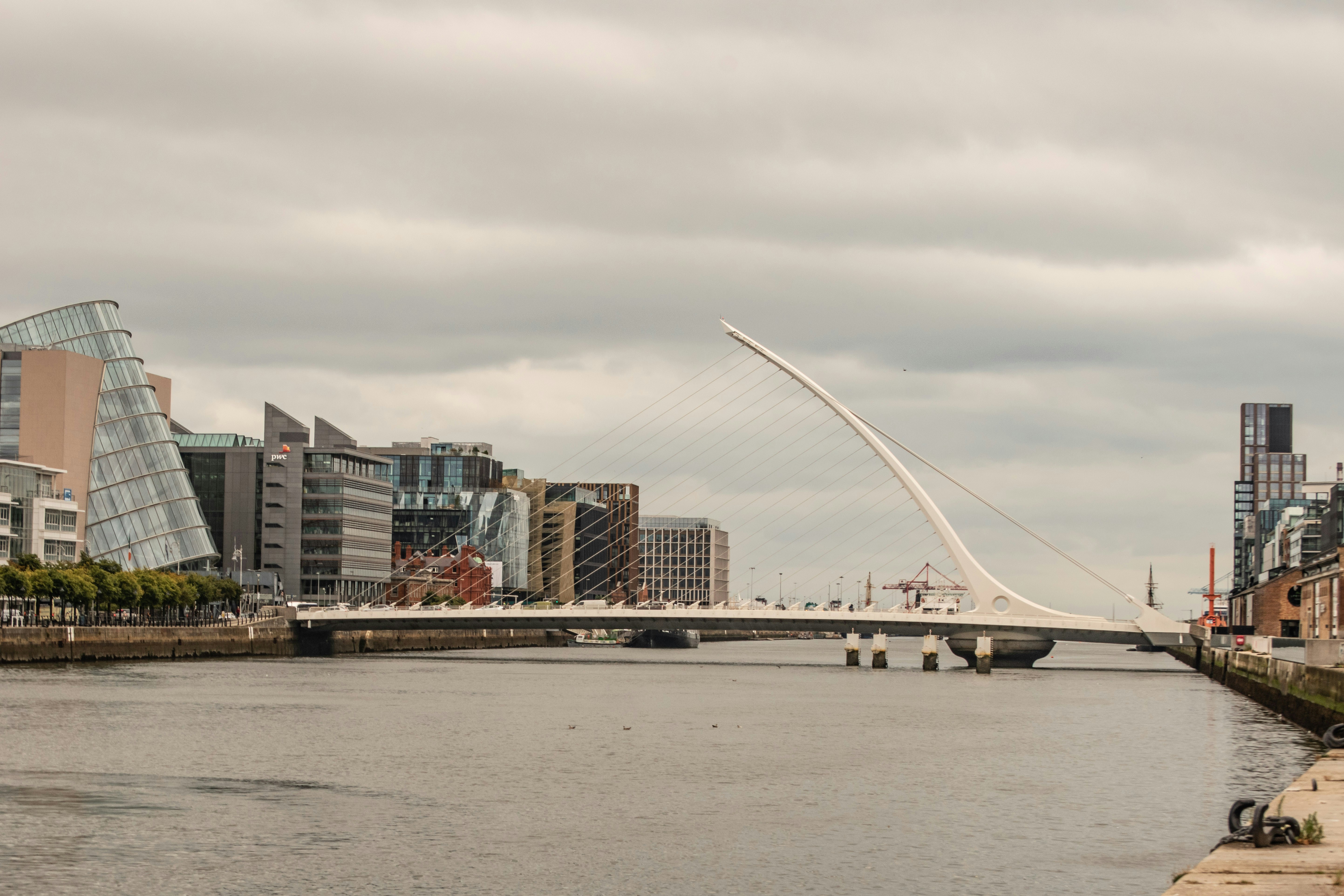 a bridge over a river with buildings in the background, 