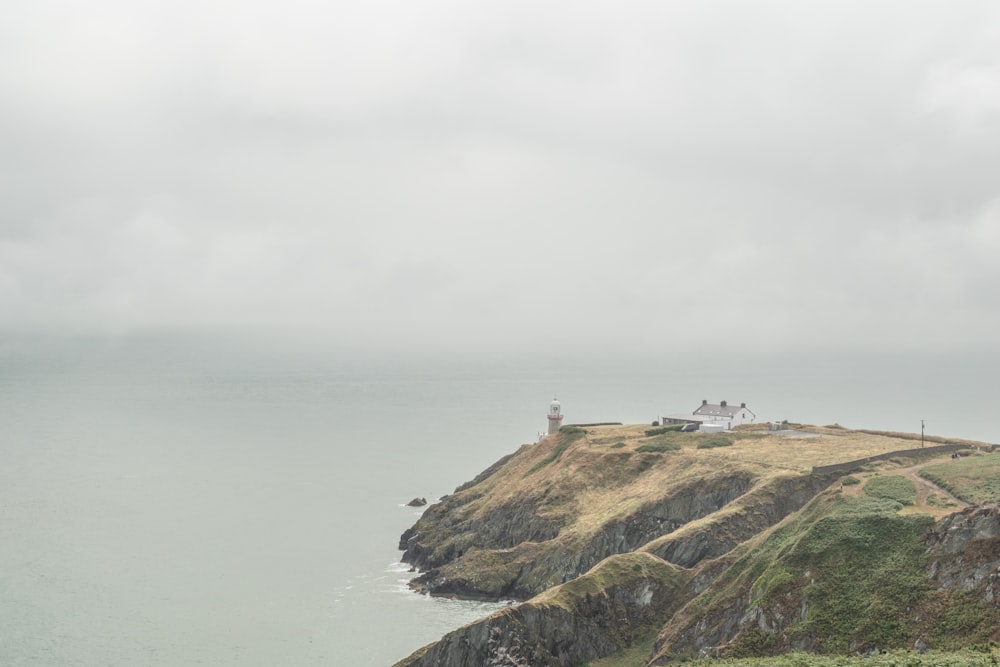 a lighthouse on a hill by the water