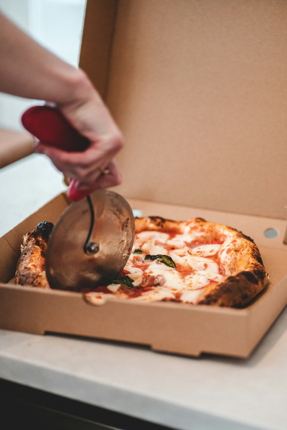 a person putting a pizza in a box