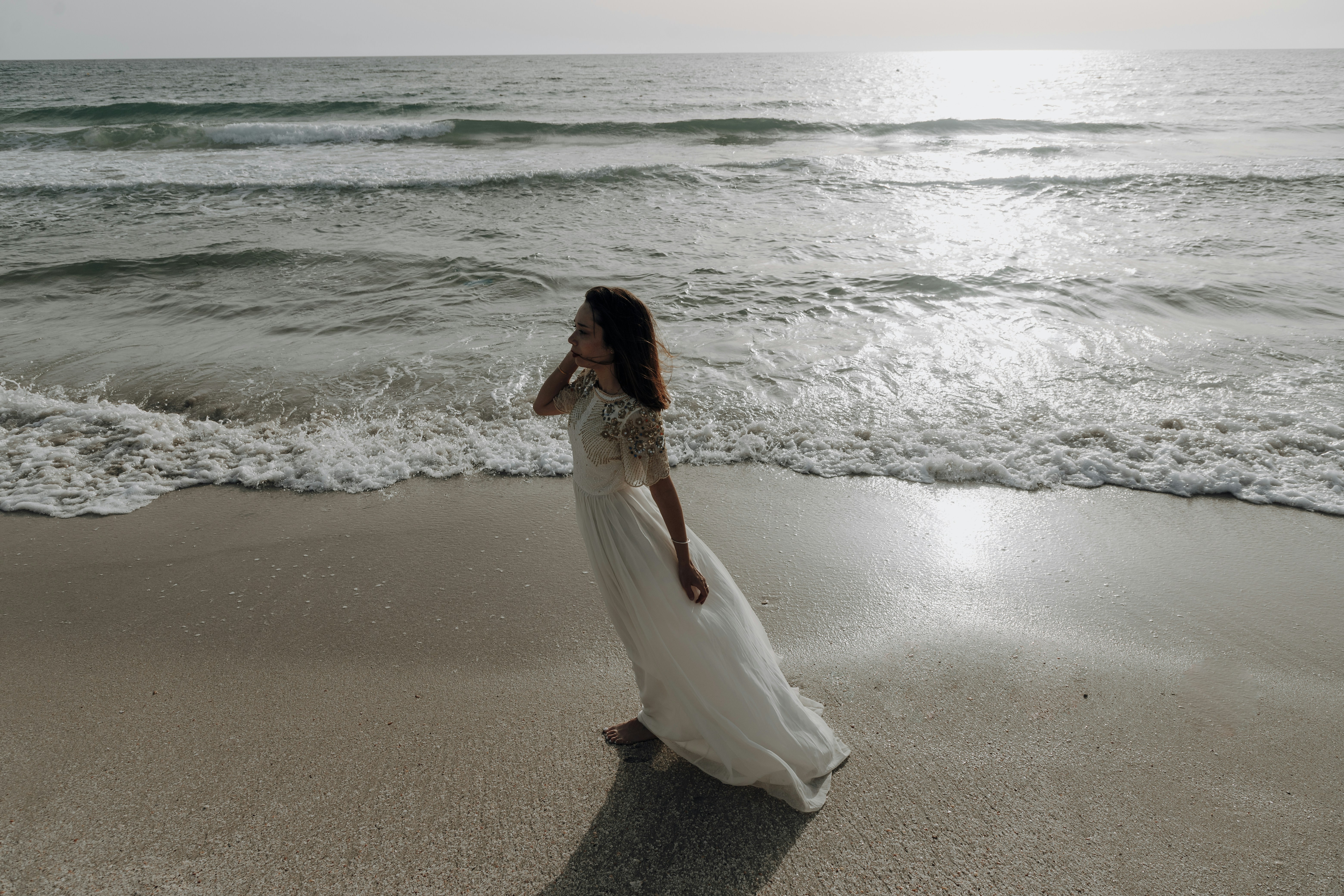 a person in a white dress on a beach