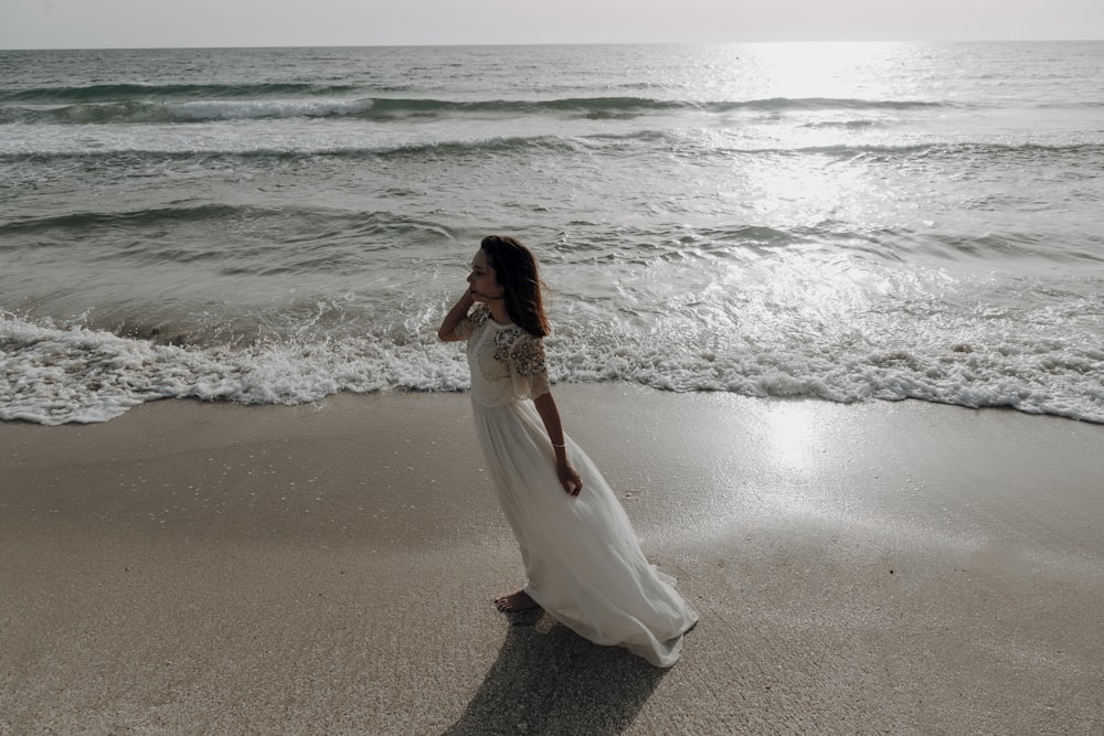 a person in a white dress on a beach