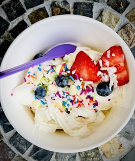 A bowl of creamy vanilla pudding topped with berries.