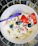 A vibrant bowl of fresas con crema topped with fresh strawberries and a sprinkle of cinnamon.