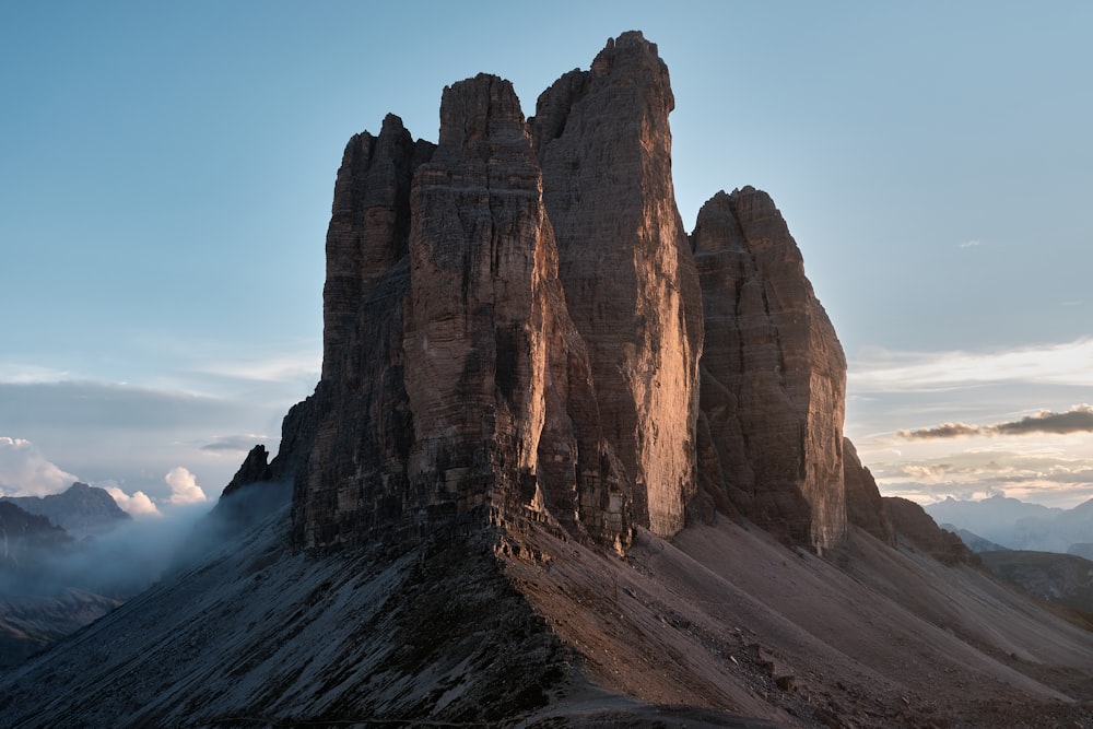 uma grande formação rochosa com Tre Cime di Lavaredo ao fundo