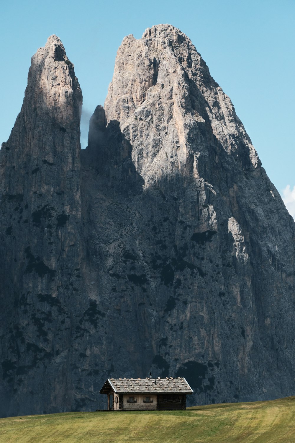 a small house in front of a large rock formation