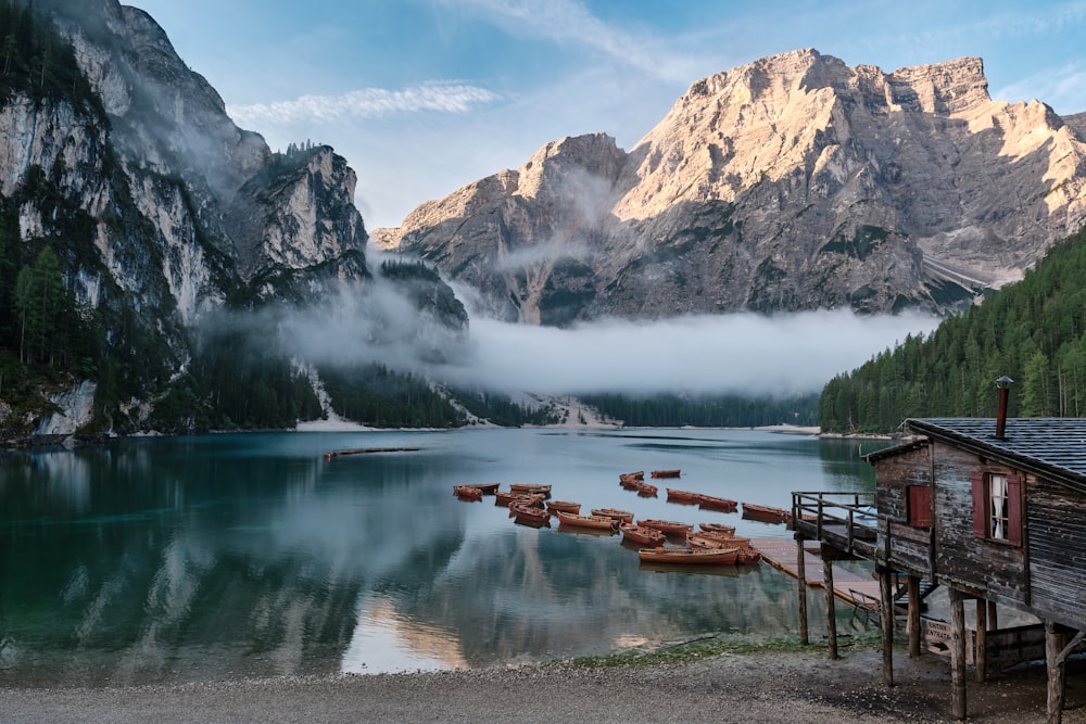 a lake with a house and mountains in the background