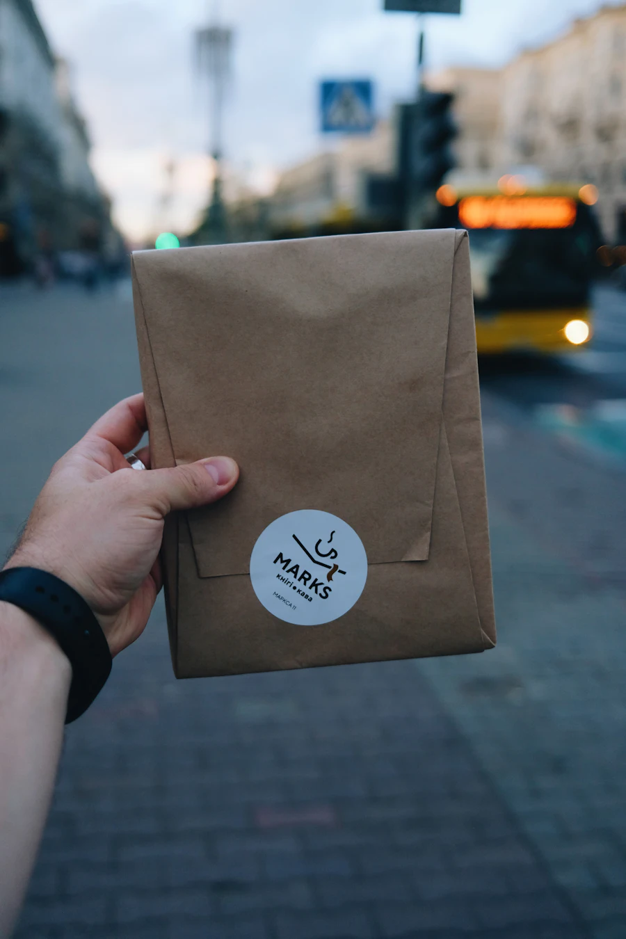 Brown paper bags printed with a shop logo, lined up on a counter.