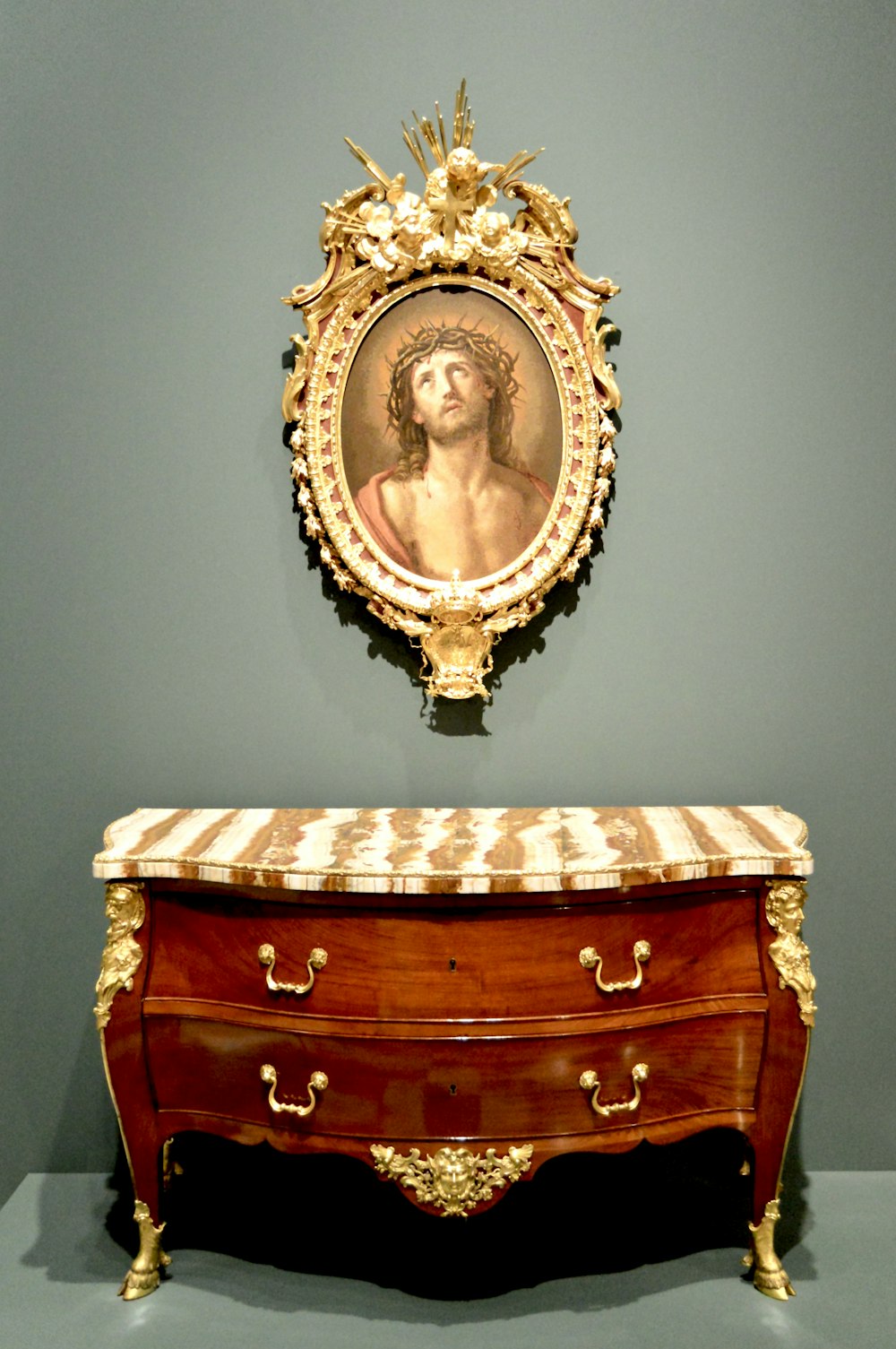 a gold and ornate chest with a picture on top