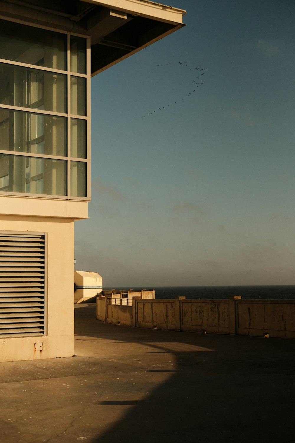 a building with a fence and water in the background