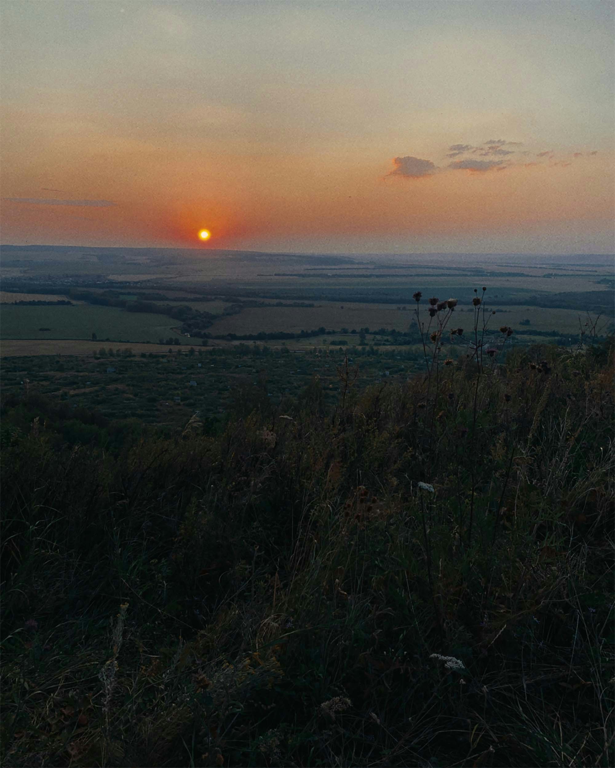 una persona in piedi in cima a un campo coperto di erba