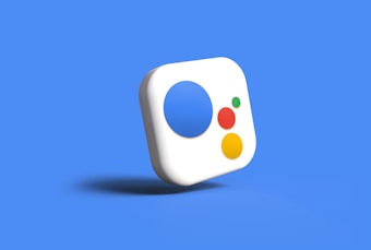 A floating 3D icon with a white background and round edges. The icon has a large blue circle, a medium-sized green dot, a medium red dot, and a small yellow dot arranged in an irregular pattern. The entire icon is set against a bright blue background, casting a soft shadow below it.