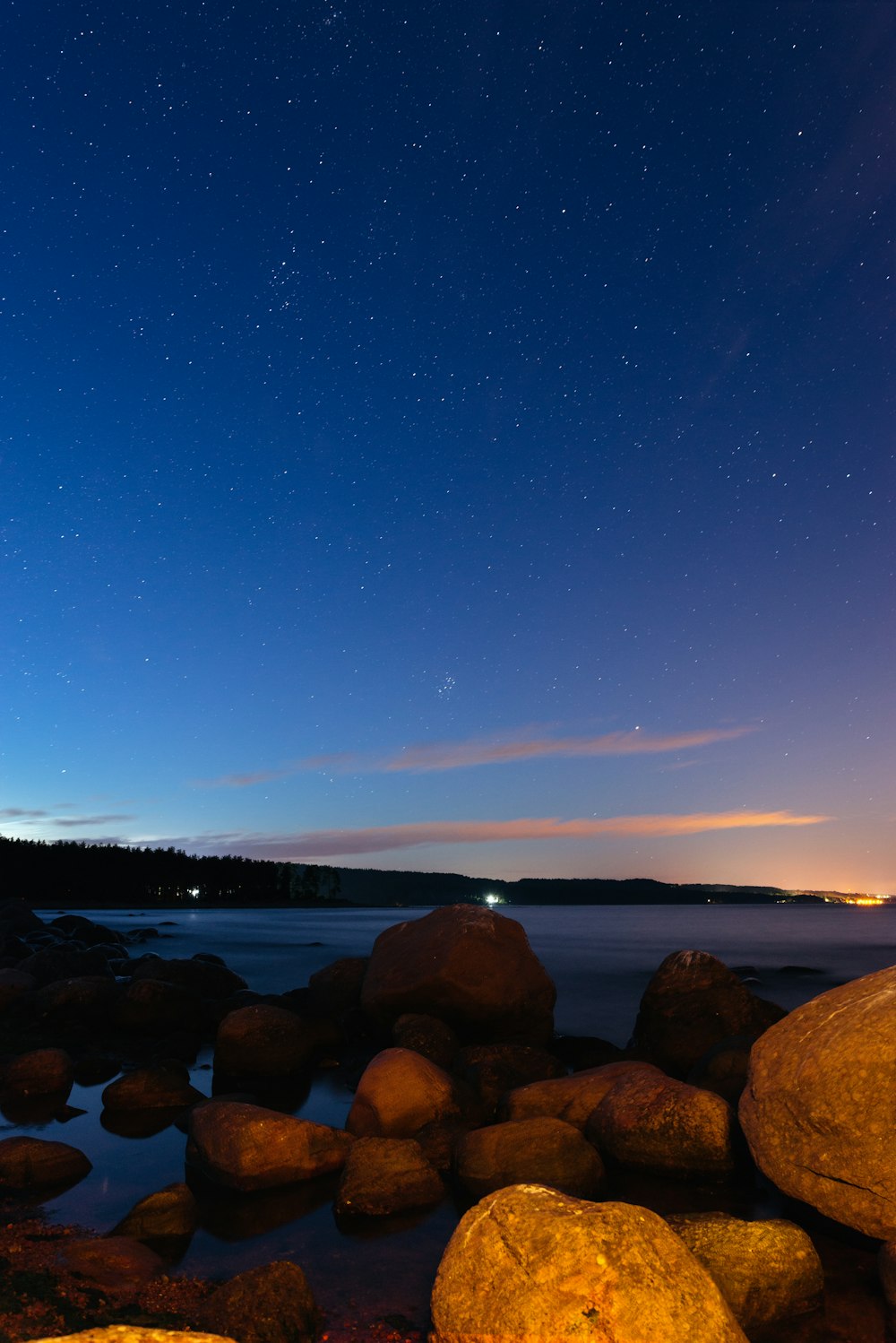 a rocky beach with a body of water in the background