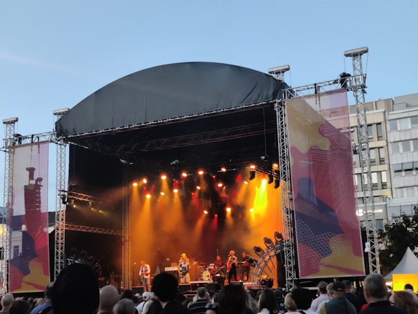A vibrant outdoor concert stage supported by sturdy scaffolding under a clear sky in Dubai.