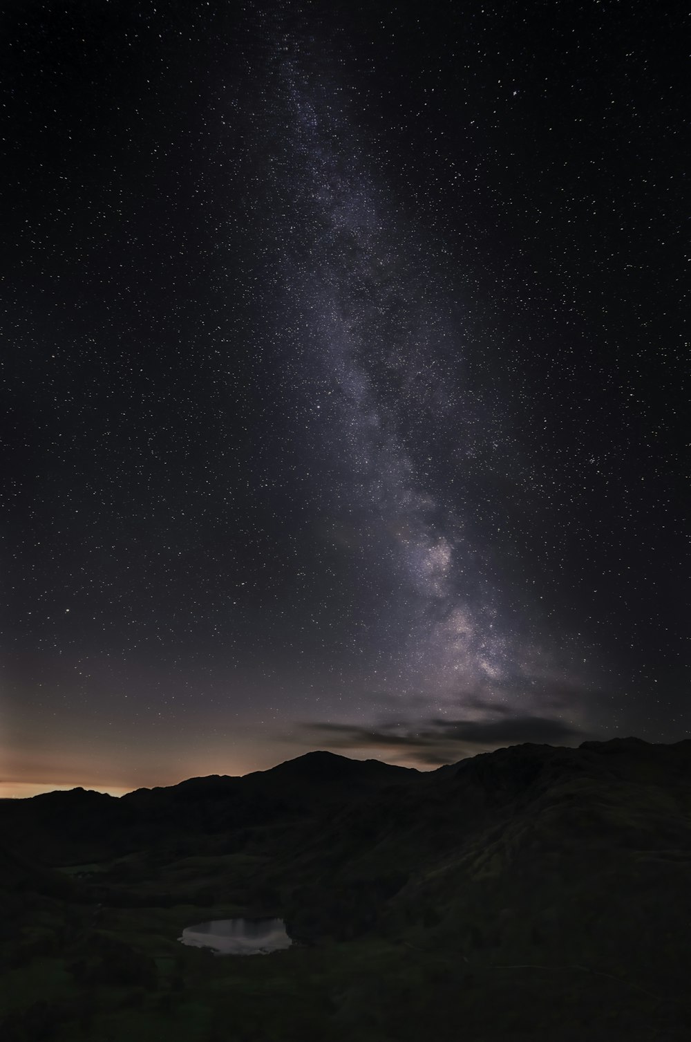 a house in the middle of a mountain under a starry sky