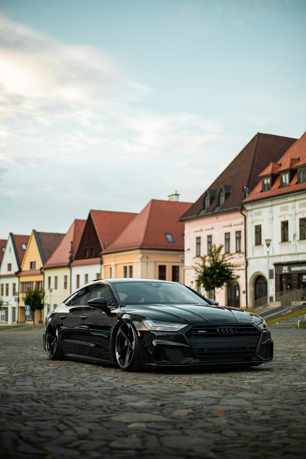 a black sports car parked in front of a row of houses