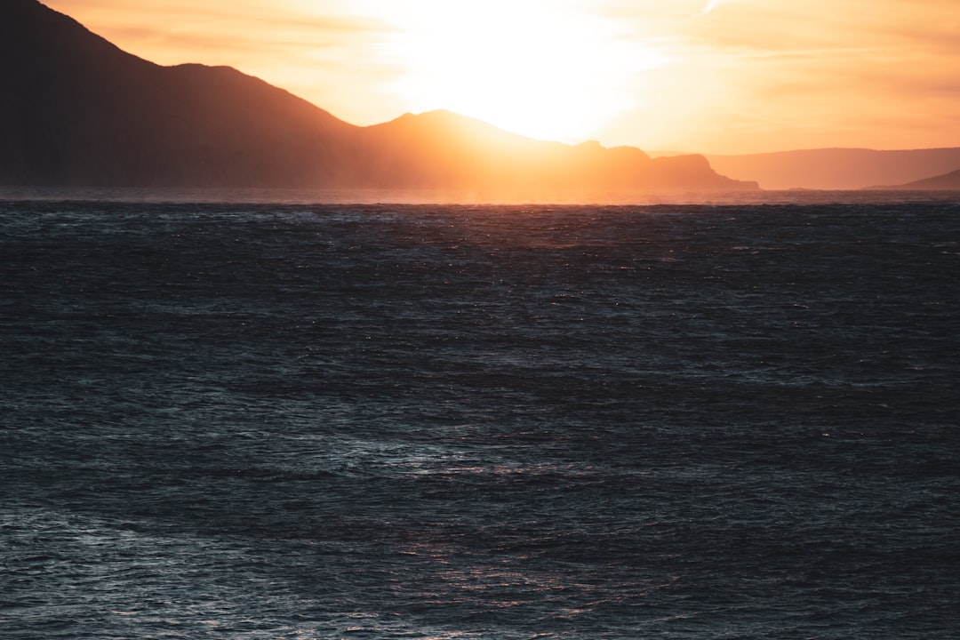 a body of water with mountains in the background,