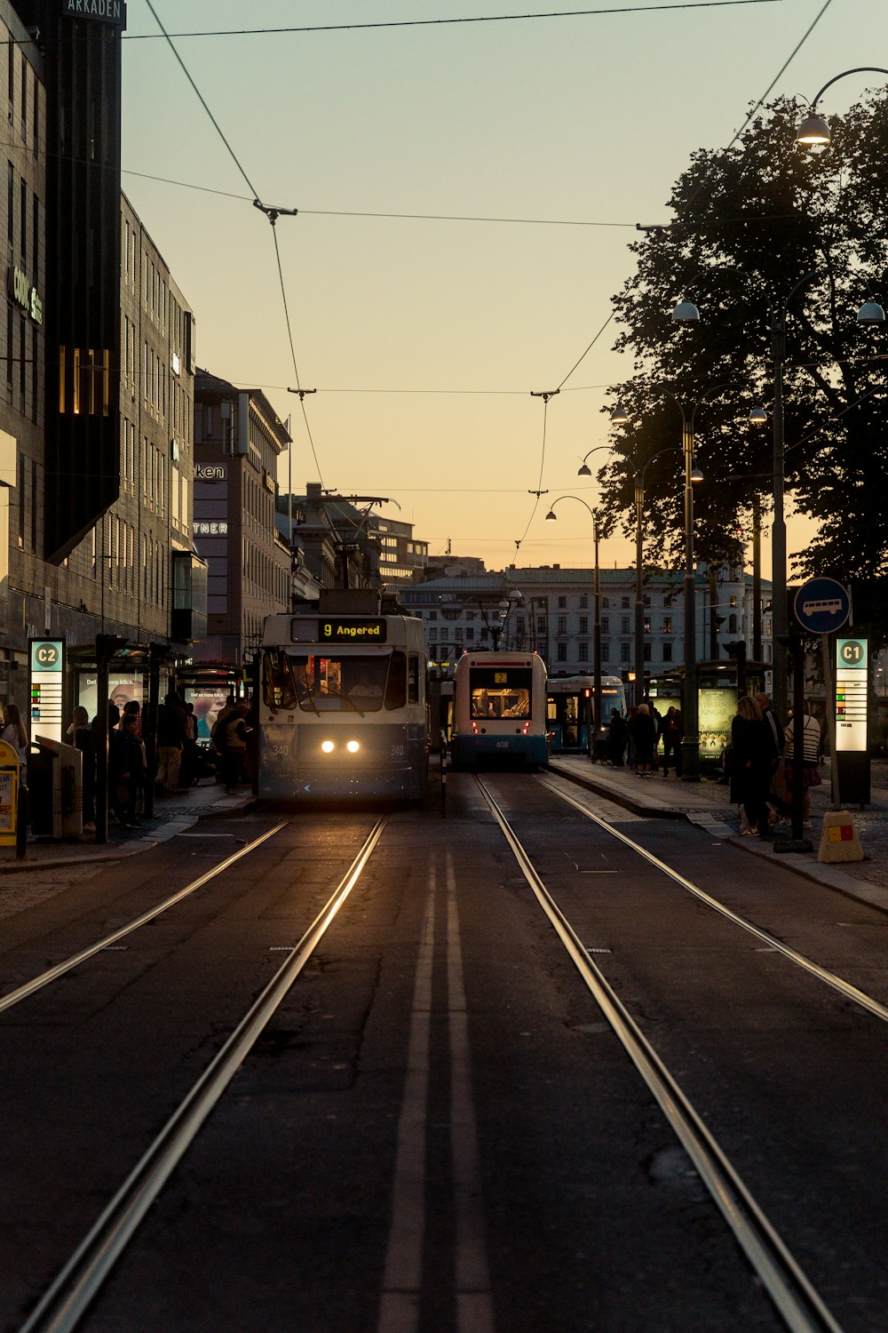 a couple of trolleys on a street with people and buildings