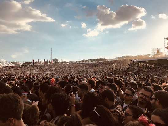 Colorful crowd enjoying an outdoor music concert under a bright sun at the festival in a picturesque mountain village.