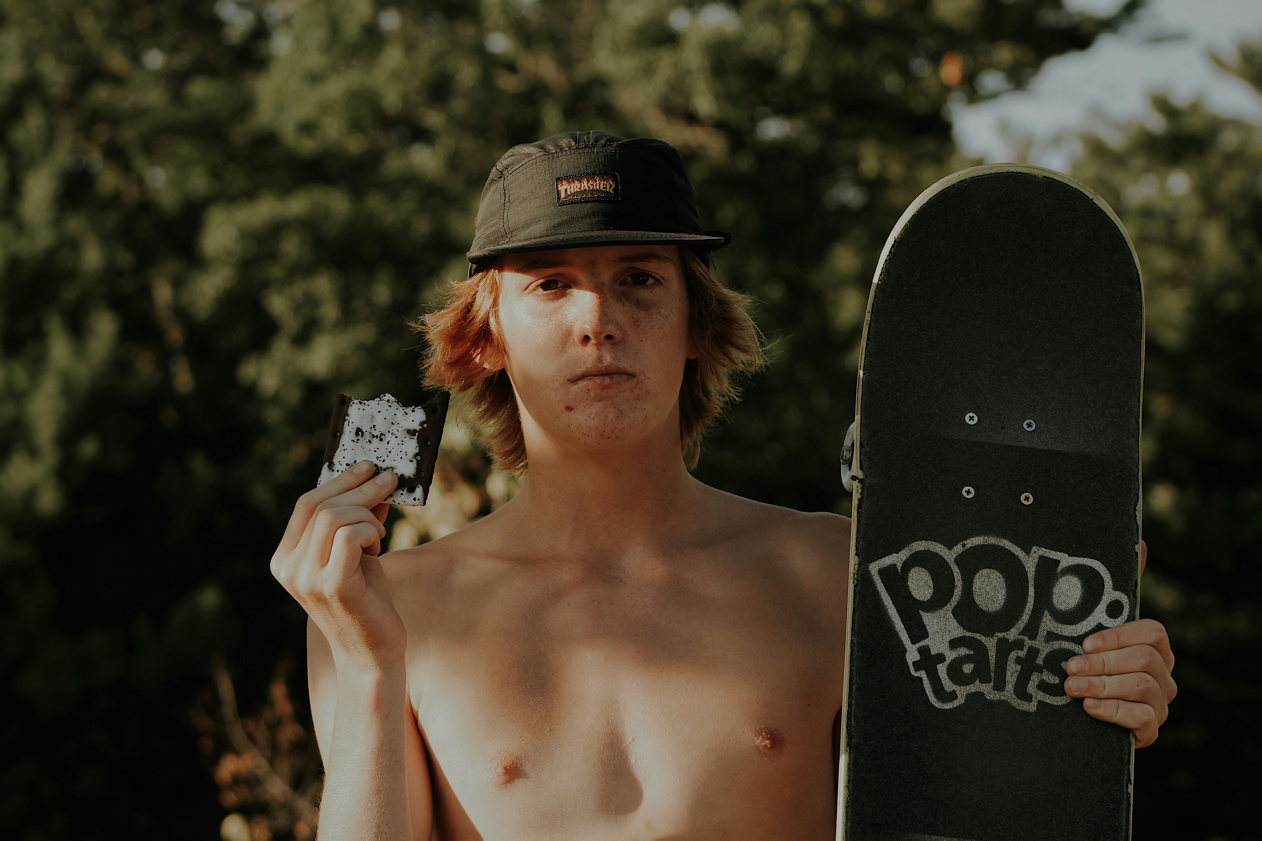 a shirtless man holding a skateboard