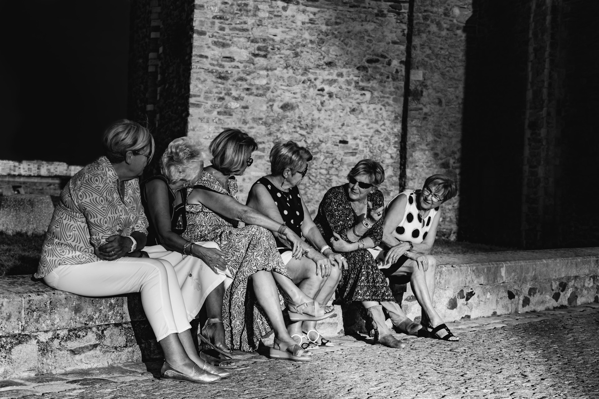 a group of women sitting on a bench with a panda bear