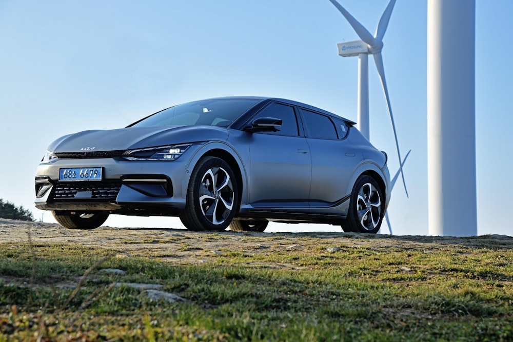 a car parked in front of a wind turbine