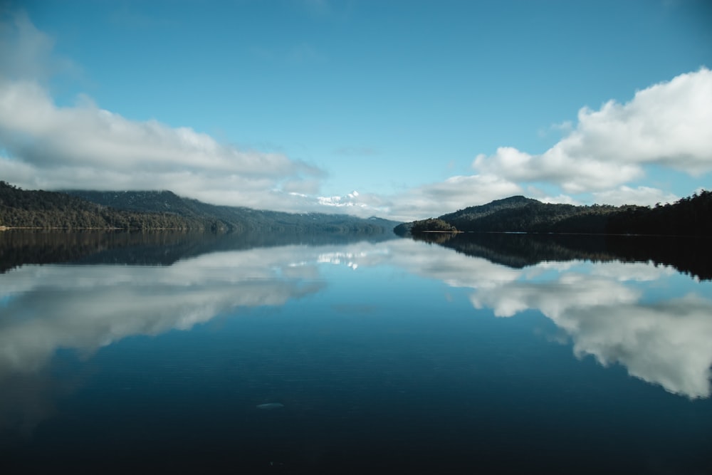 a body of water with hills in the background