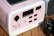 A satisfied customer holding the surge protection device with a backdrop of home electronics.