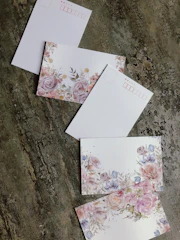 Close-up of elegant illustrated postcards arranged neatly on a white surface.