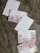 Several postcards are arranged on a textured surface. Each postcard features floral designs with pastel-colored flowers, including pinks, purples, and blues. Some postcards have a designated area for address and stamps, outlined in red.