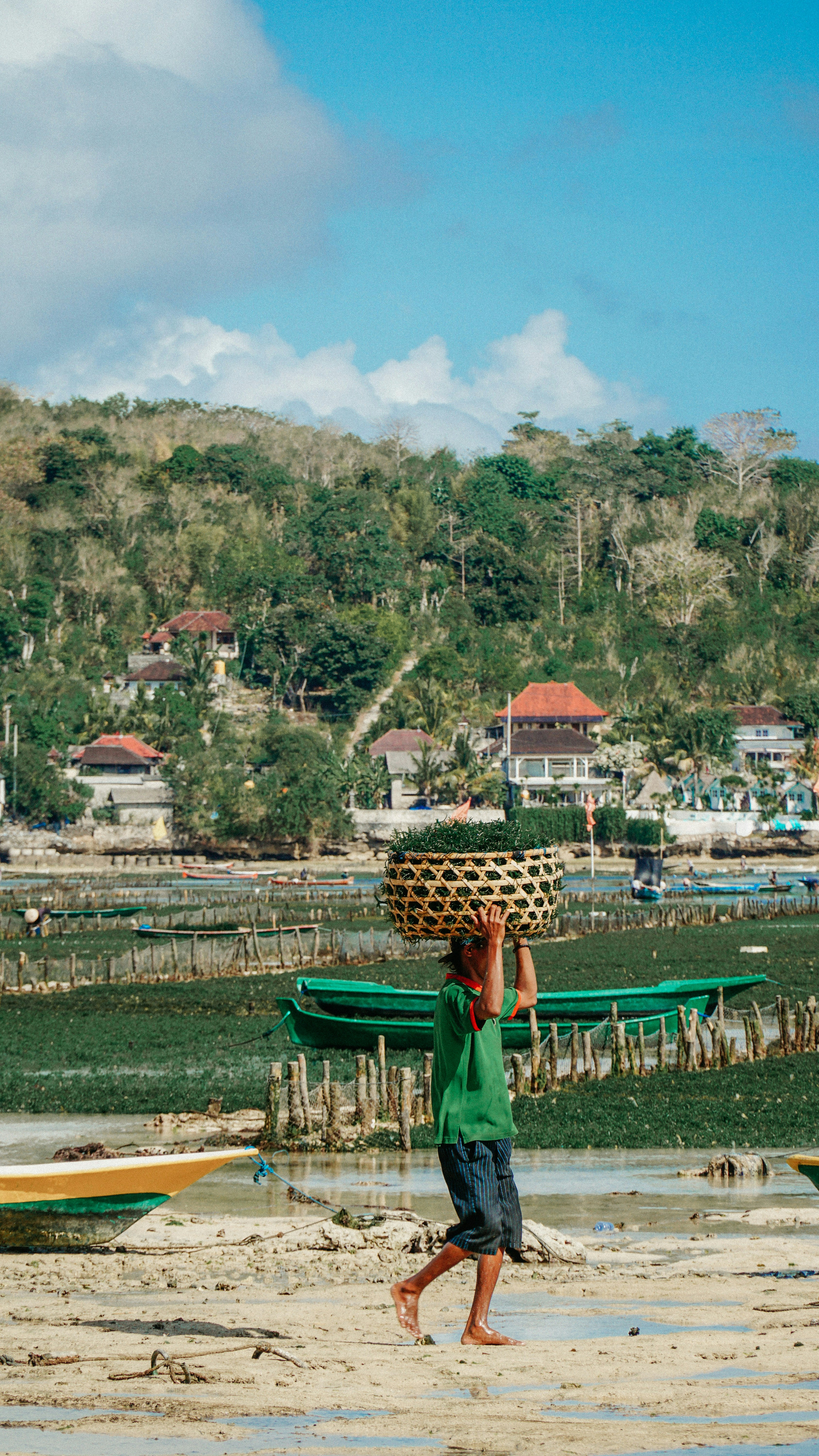 a person carrying a basket on the head on a beach