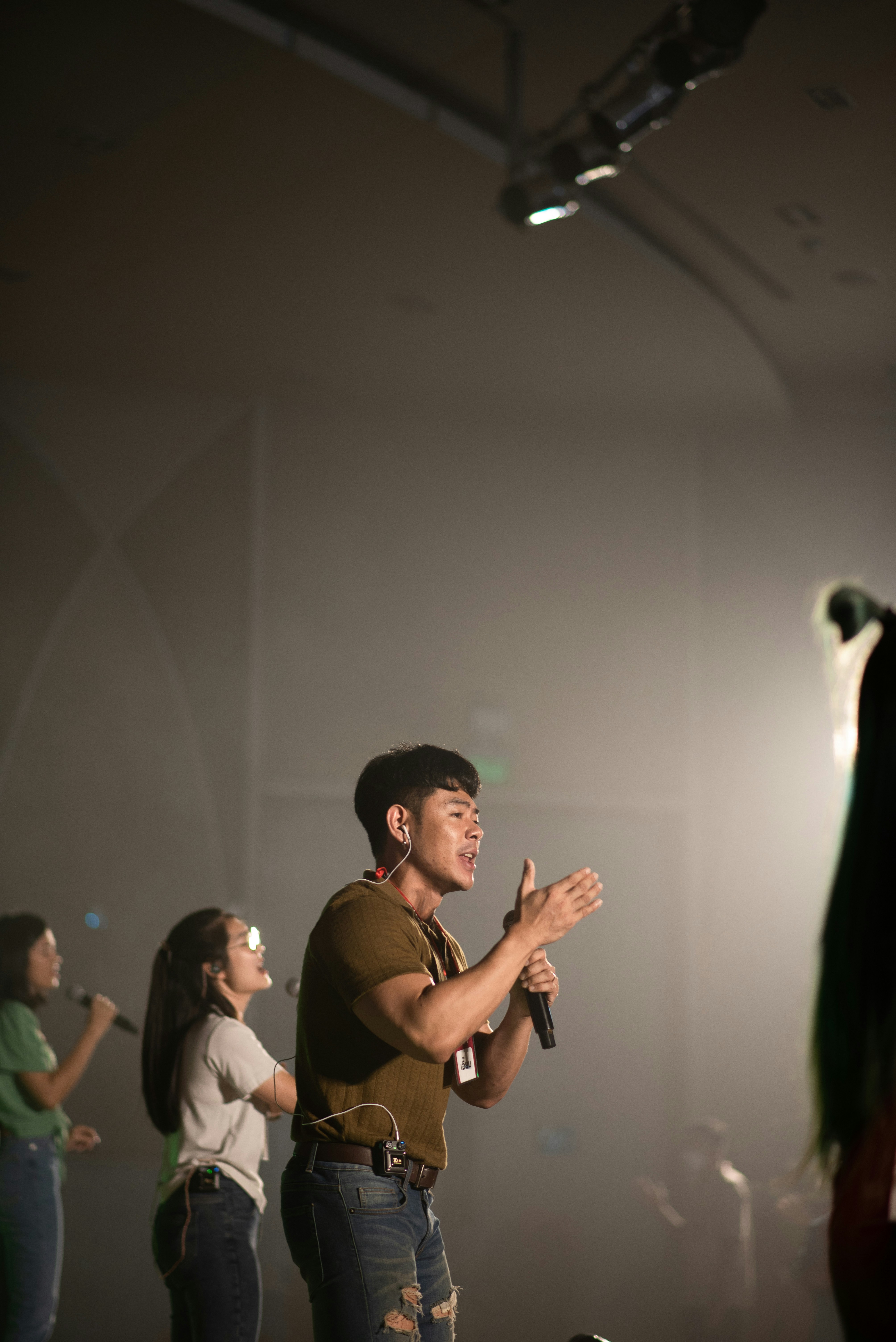 a person holding a microphone and standing in front of a group of people