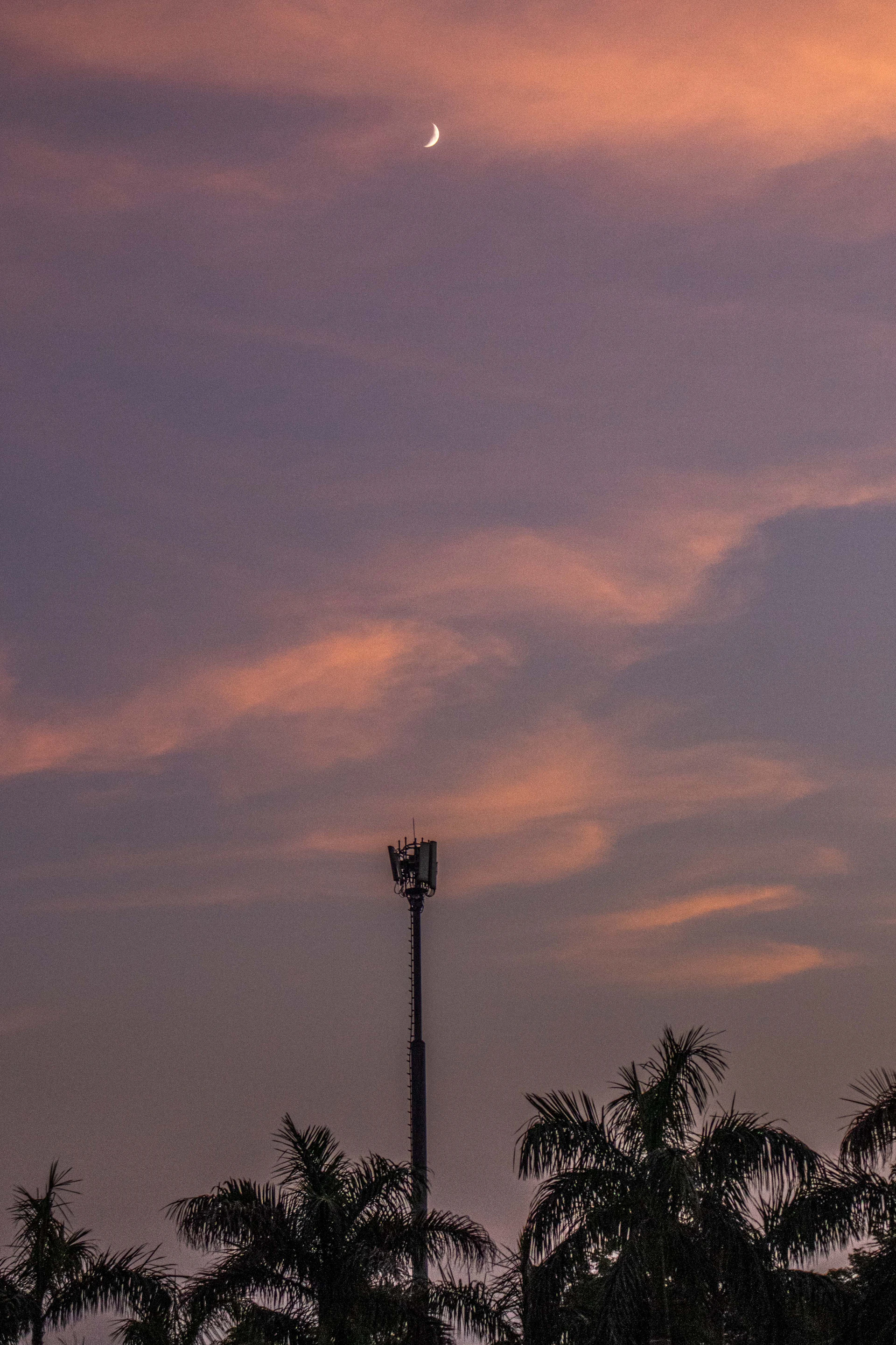 a tall tower with a moon in the sky