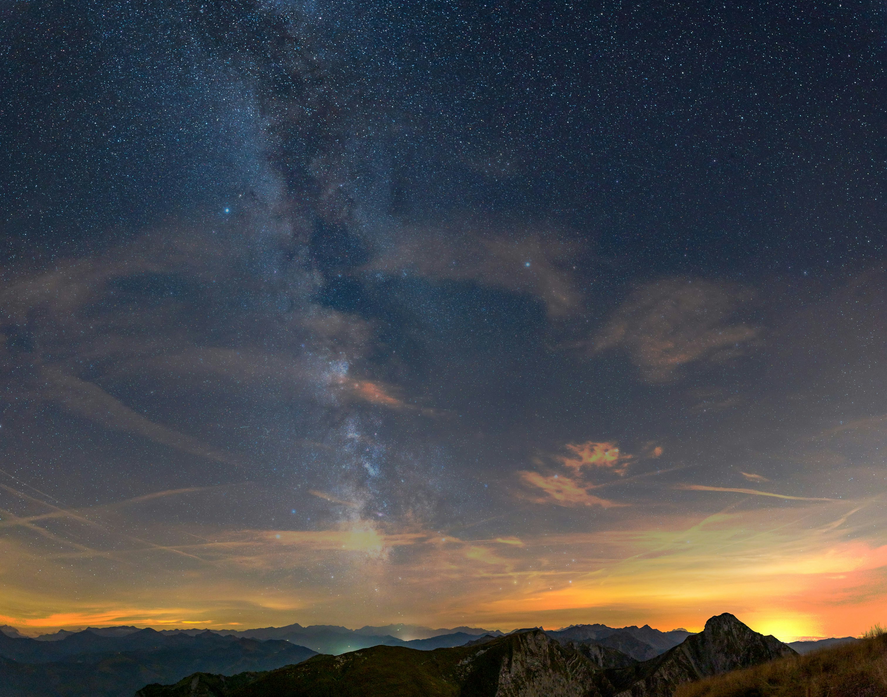 a starry night sky over mountains