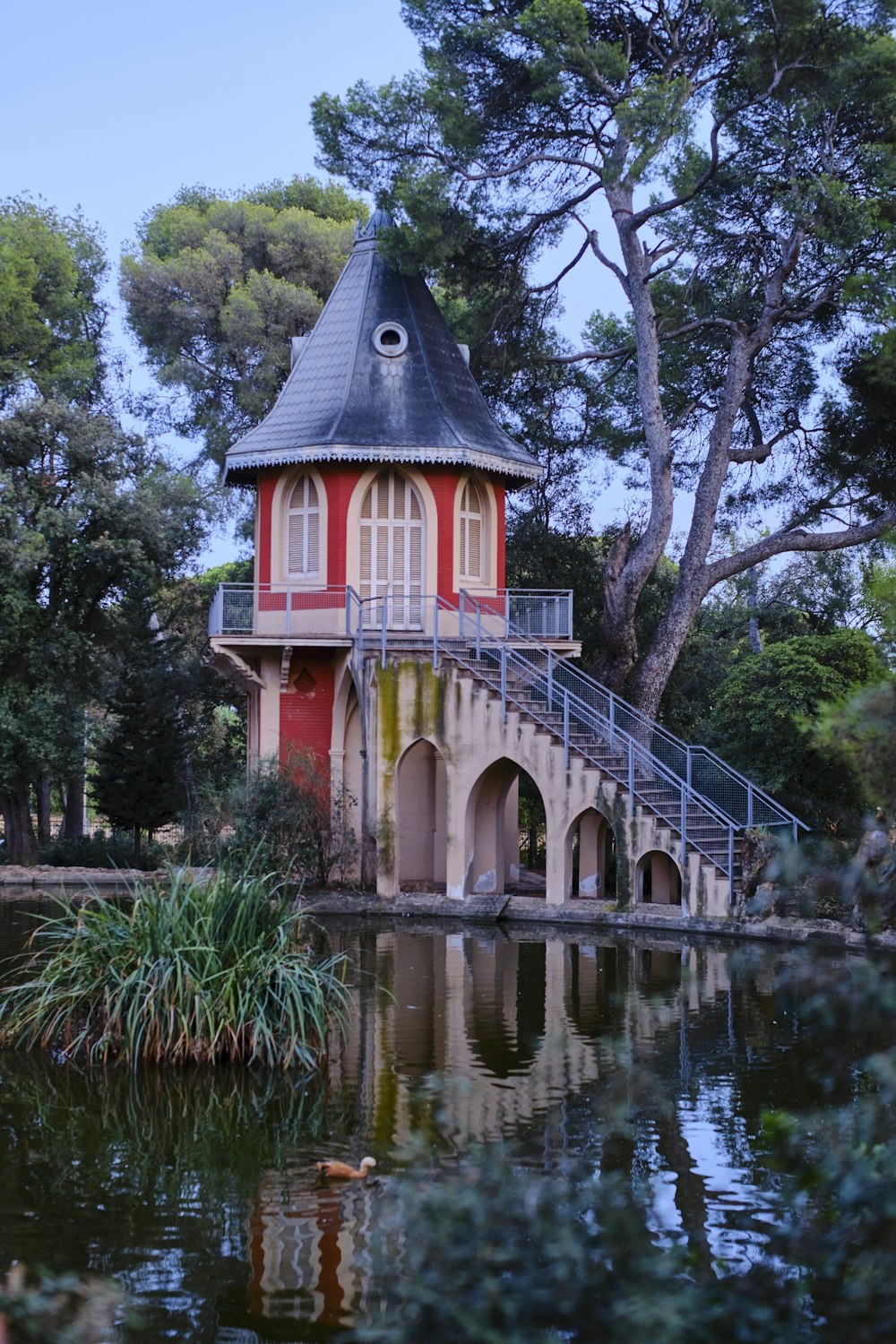 a red and white building on a bridge over water