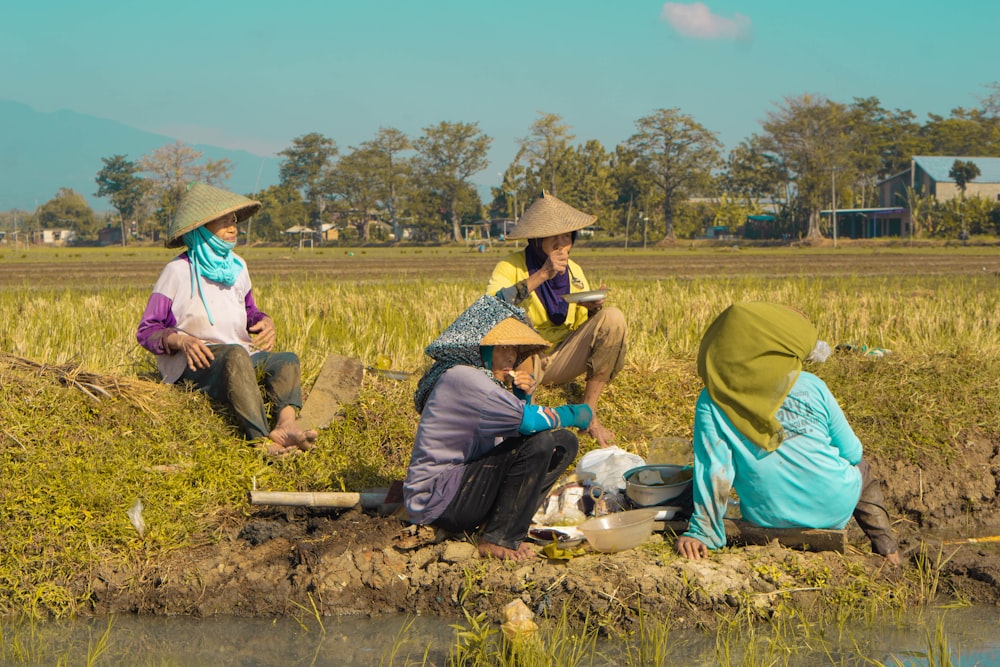 a group of women sitting in a field