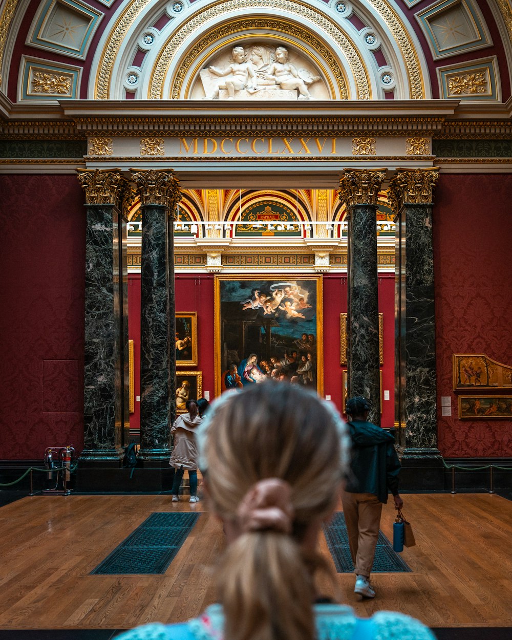 a person taking a picture of a painting on the wall