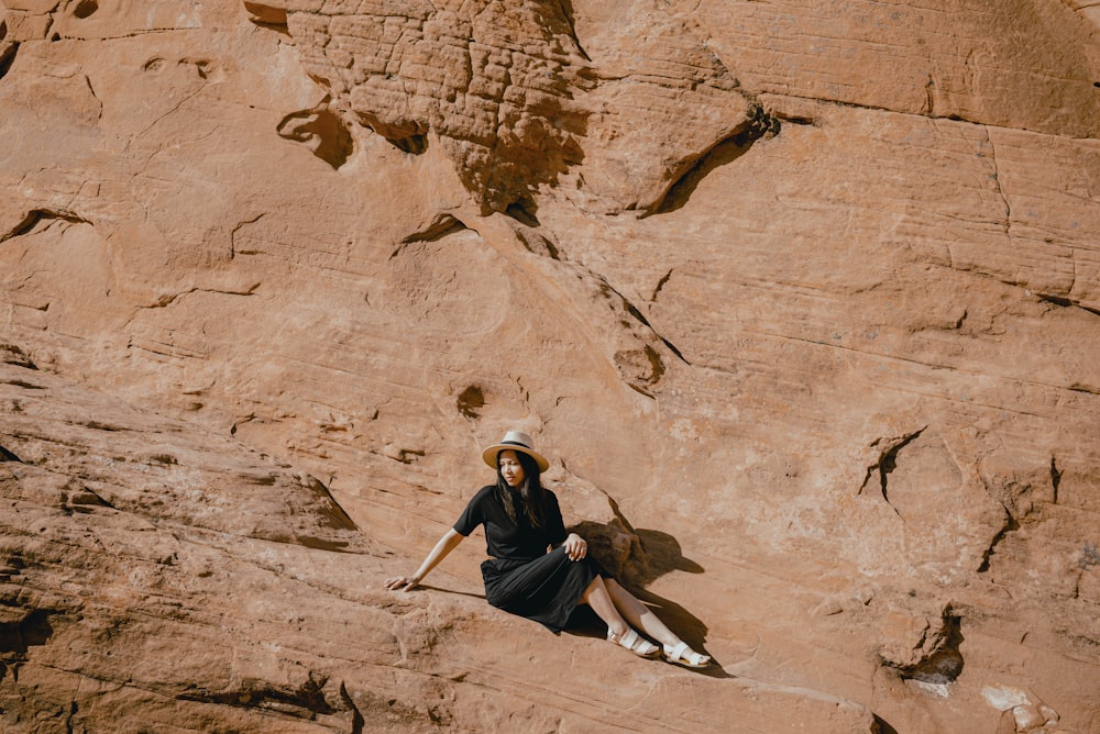 una persona seduta su una roccia
