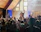 A lively corporate gathering with a male singer engaging the crowd on stage.