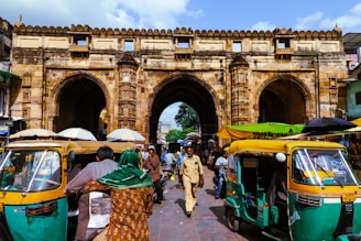 A lively street scene in Mumbai with colorful market stalls and the Gateway of India in the background.